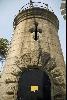 The old Green Island lighthouse, built in 1875, features projected rock-faced quoins and cross-shaped openings.
