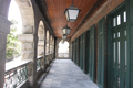 The open verandah, with pendant lights, boarded ceiling and timber shutter doors, of the Old Mental Hospital.