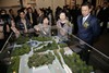Mrs Lam (second from right) and Mr Barry Cheung (first from right) showing great interest in the model of Hong Kong Heritage Discovery Centre.
