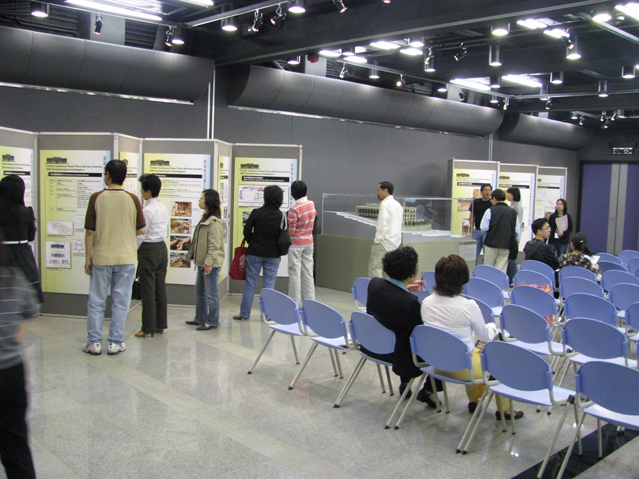 Participants looking at display panels and the model of the Central School