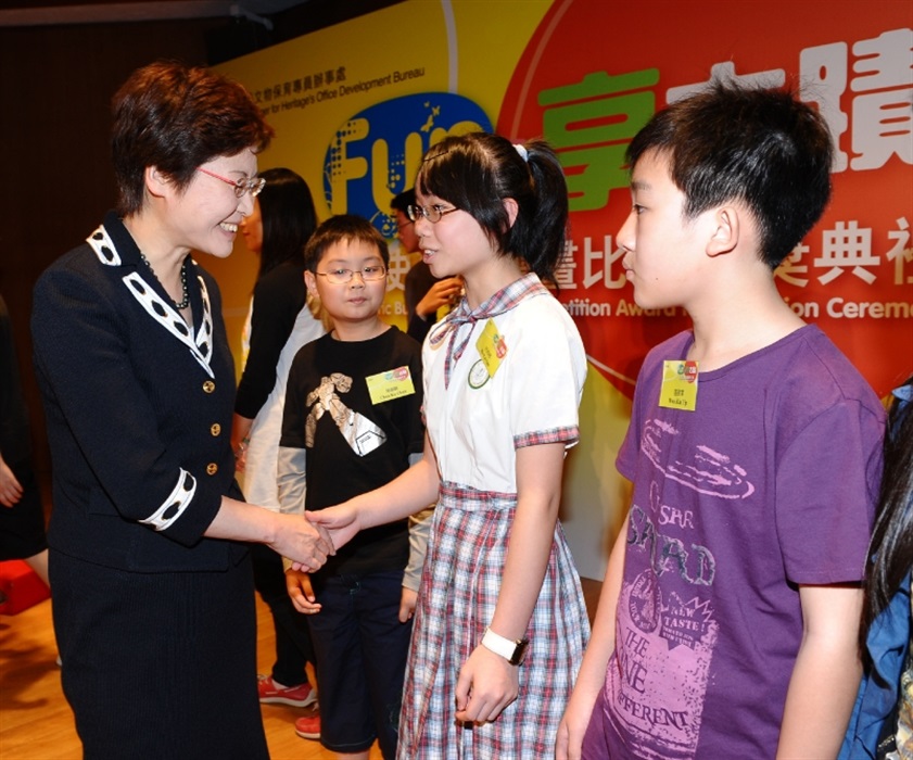 The Secretary for Development, Mrs Carrie Lam, chats with the award winners of the Historic Buildings Drawing Competition.