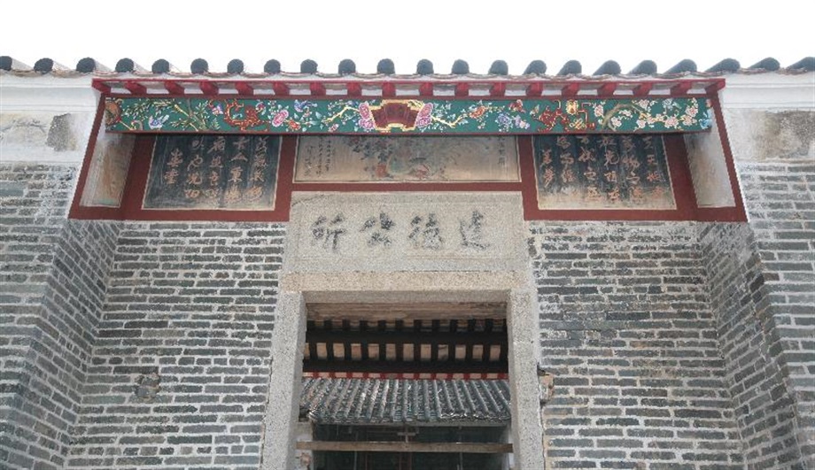 The granite name plaque and murals at the main entrance of Tat Tak Communal Hall.